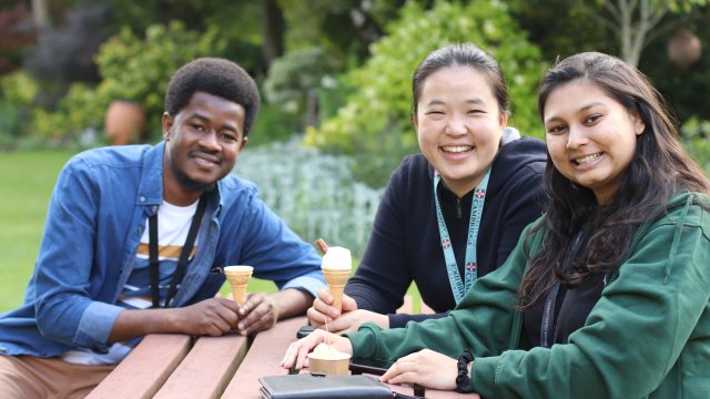 Ǻ students sit outside with ice creams in the sundial garden