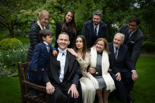 A family gathers around a recent graduate of Ǻ